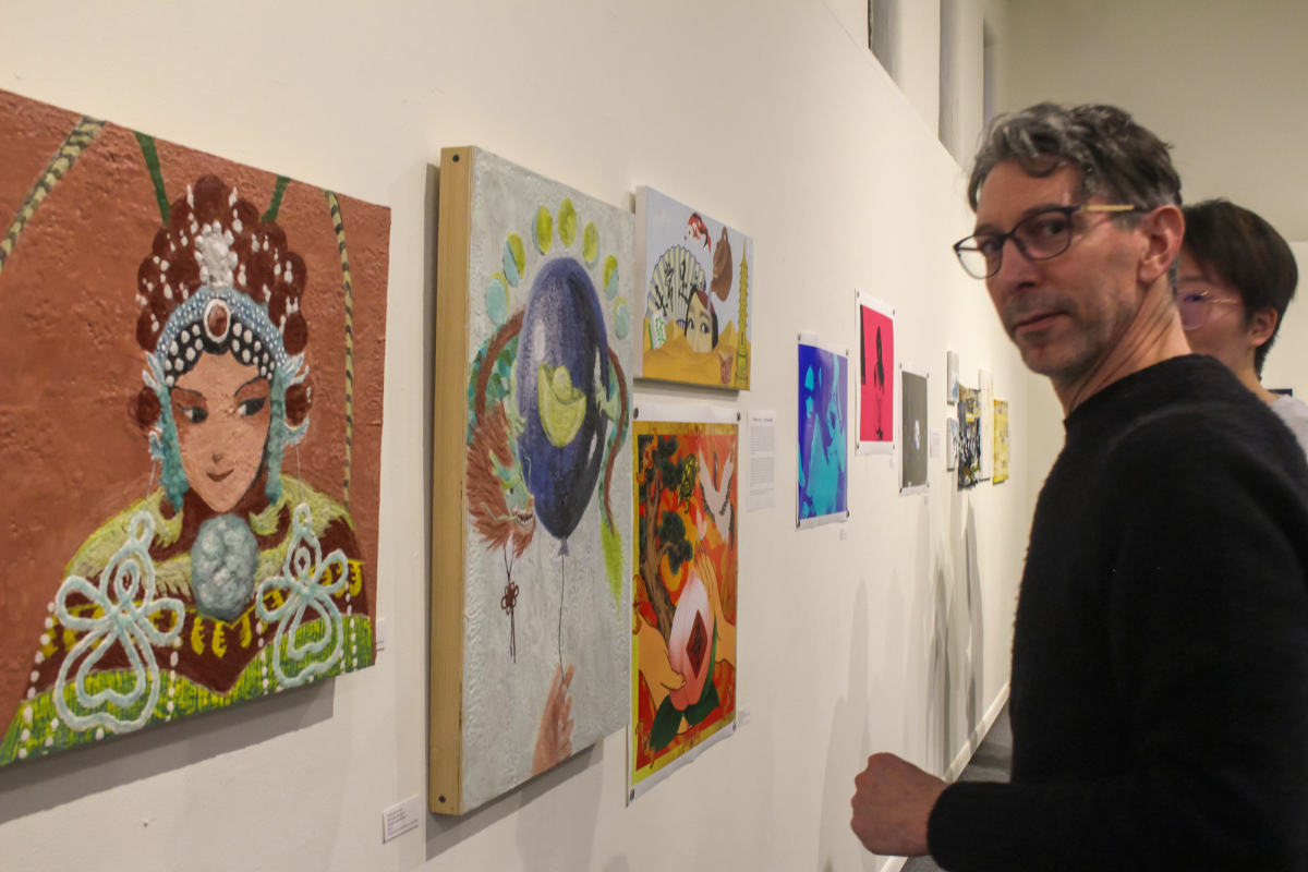Andrew Kaufman, professor of studio art, poses for a photo in front of Stephanie Liao `26’s pieces.
