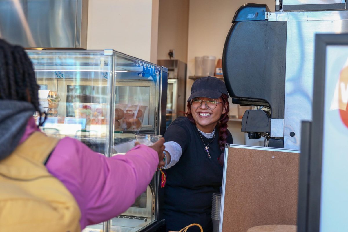 Genesis Mendoza `28 (center) hands a customer a cup of ice at the Spencer Grill on Tuesday, Jan. 27.