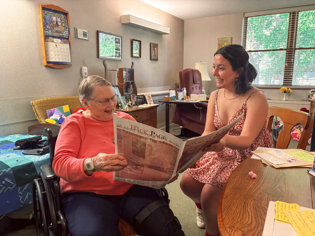 Karla Breed and Thai Theodoro `27 read The Scarlet & Black together at Mayflower Community.