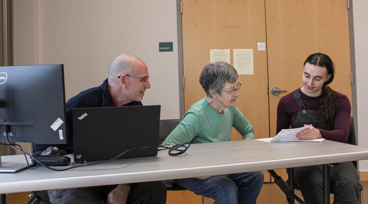 From left: Lee McFee, Emily Moore and Maya Flynn `26 at Drake Community Library on the opening day of the
program.