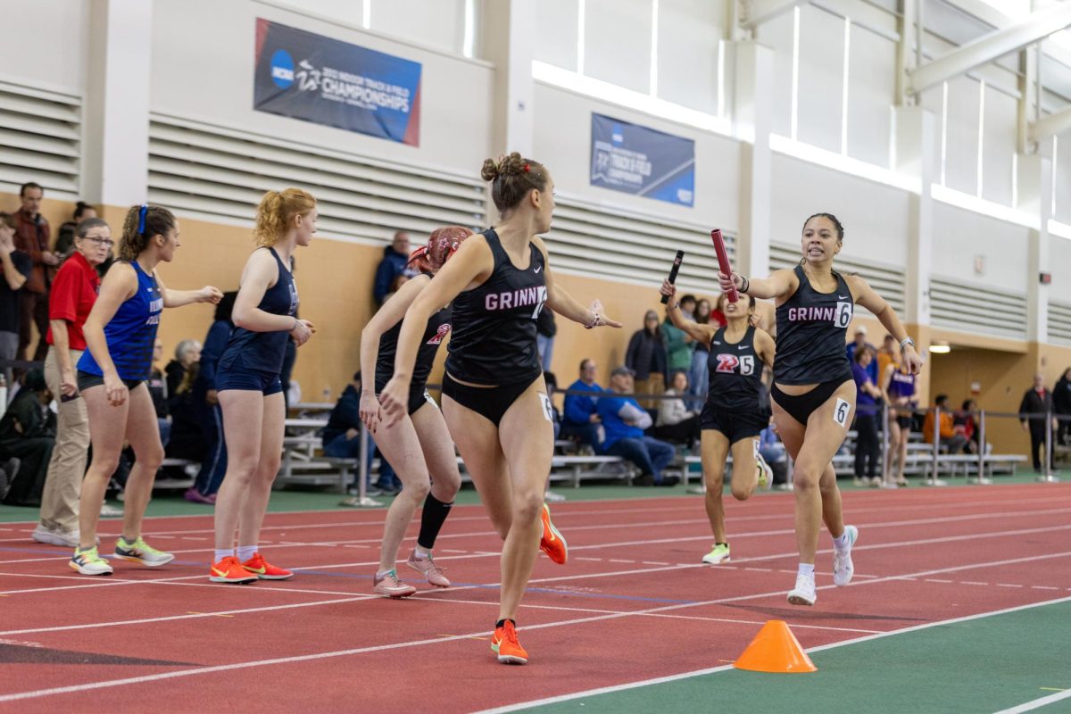 Noelle Vu `28, right, hands the baton to Tennyson Shultz `28, center, in the 4x400-meter relay at the MWC Meet in the Bear Field House on Saturday, Feb. 28.
