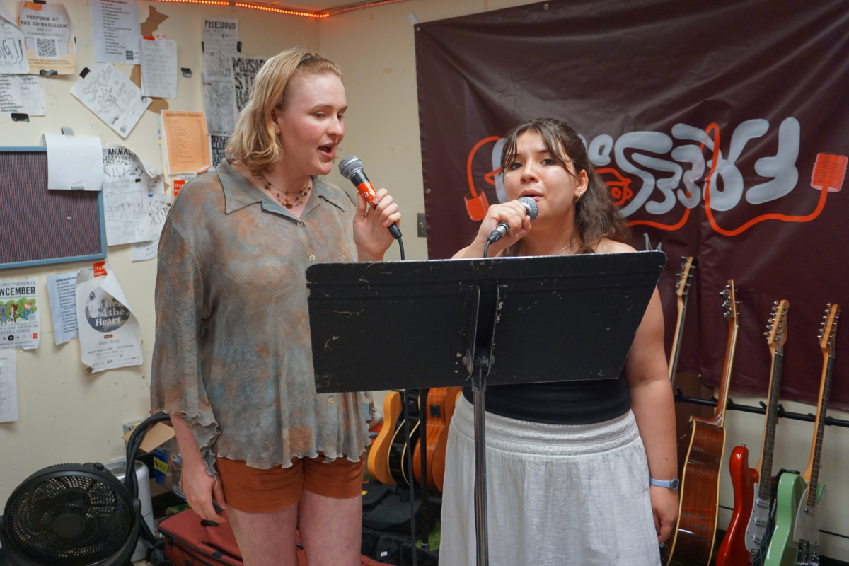 From left: Syd Weller `26 and Violet McCloskey `28 sing together at a rehearsal prior to a Grateful Dead-inspired concert, which will be a fundraiser for Iowa Crisis Intervention Services.