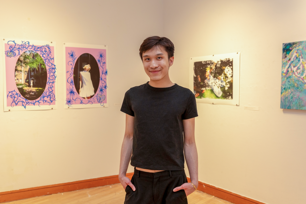 Chris Nguyen `27 stands in the center of the Smith Gallery surrounded by his work on Thursday, March 26.